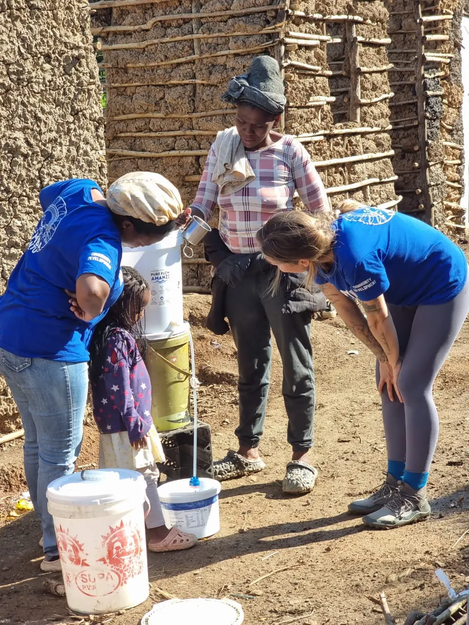 PureFlow Amanzi field team visiting a household to demonstrate and check a water filter