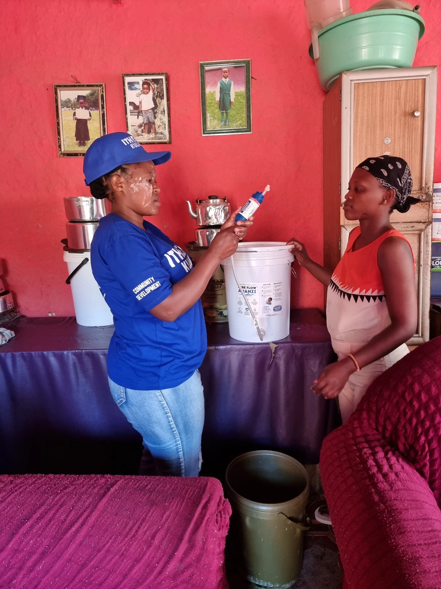 PureFlow fieldworker showing a filter component and maintenance procedure to a resident inside her home