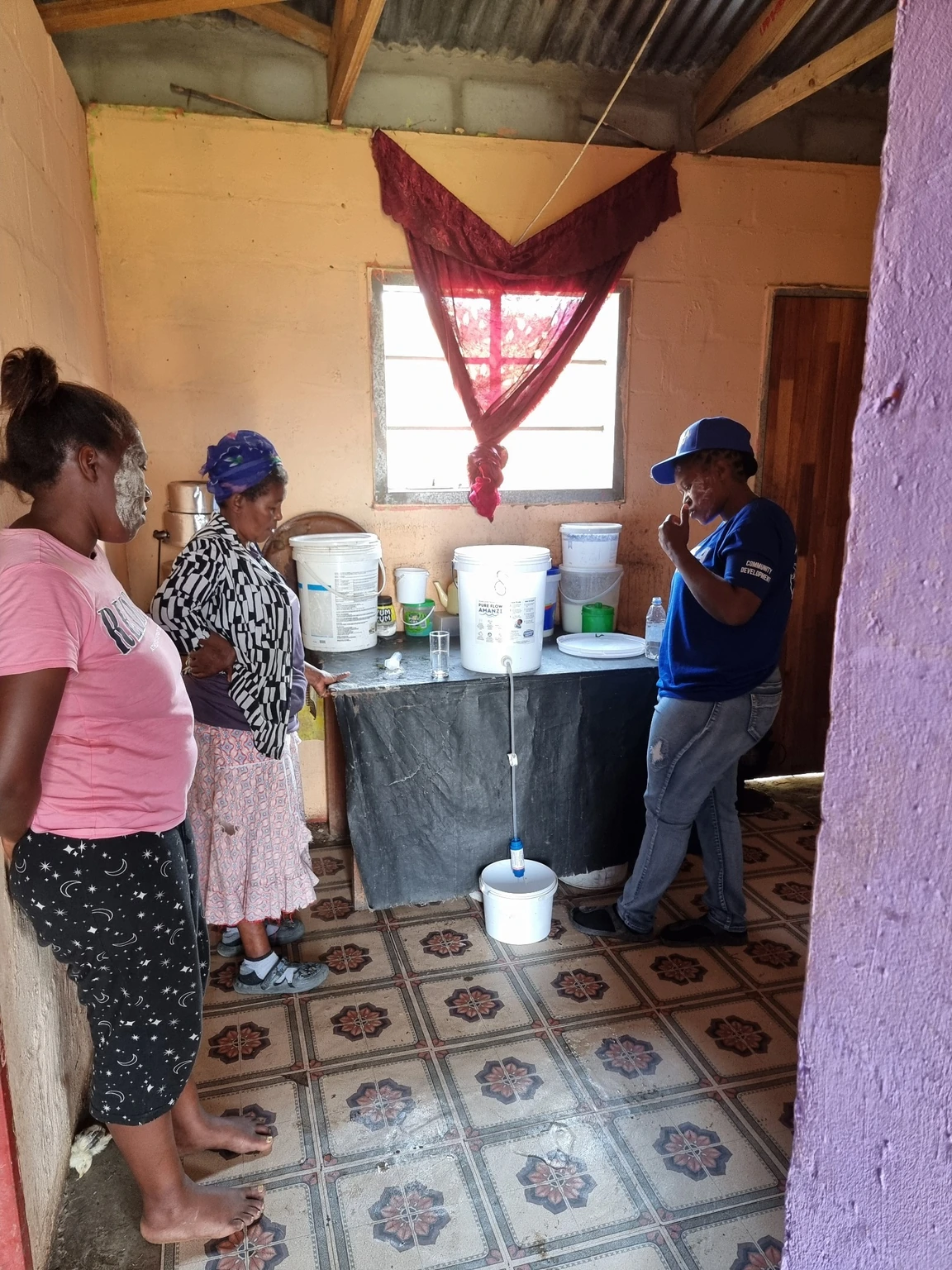 Residents beside an installed PureFlow water filter inside a family home